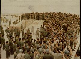 Miembros del Ejército iraquí jalean a Sadam Hussein (1937-2006) sobre una trinchera.