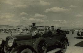 Fotografía impresa en papel postal de Mustafá Kemal, "Atatürk" (1881-1938) sentado en su automovil descapotable y saludando con su sombrero de copa en mano, c. 1930.